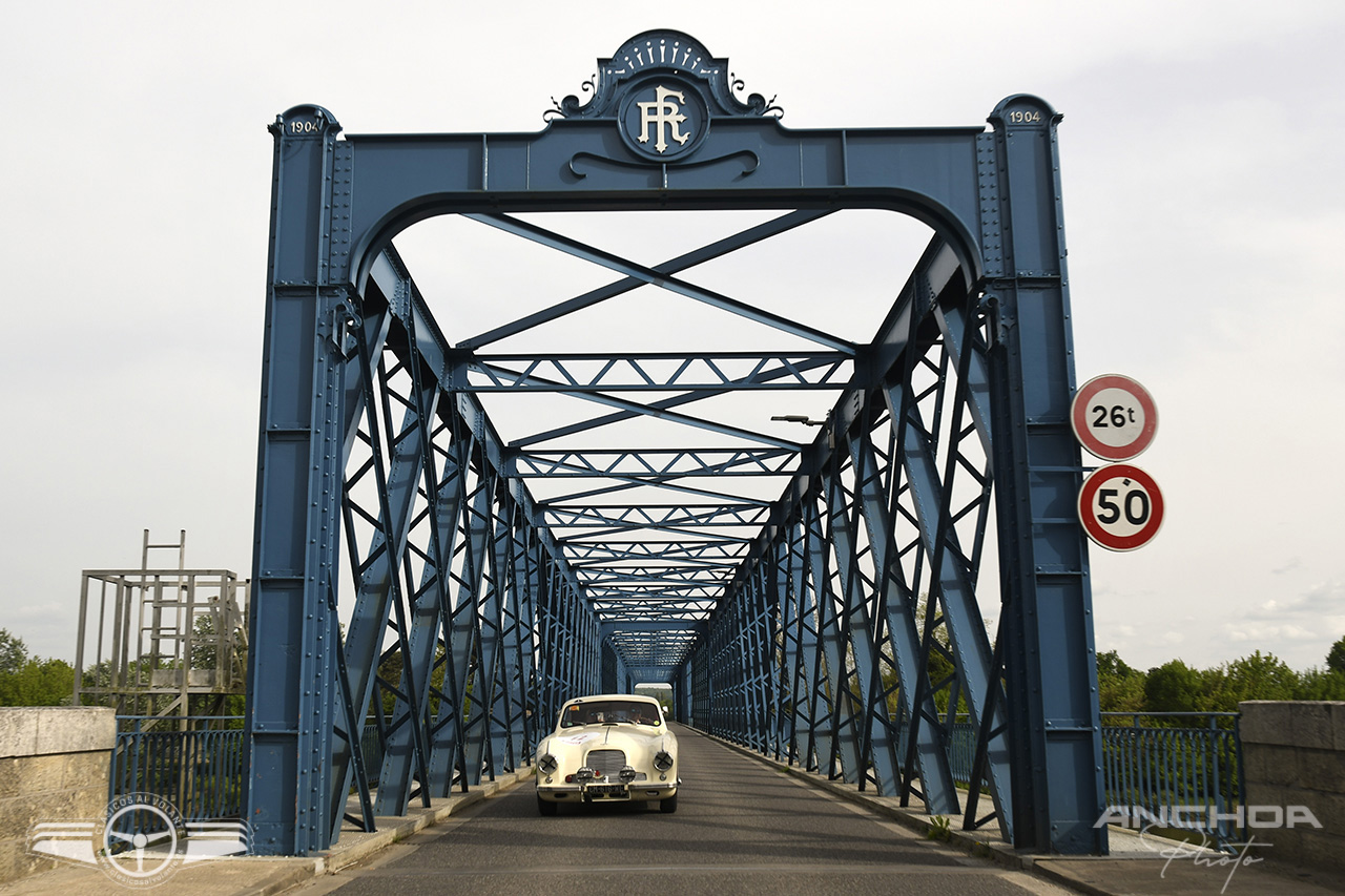 Un elegante Aston Martin DB2 de 1953 cruzando un antiguo puente