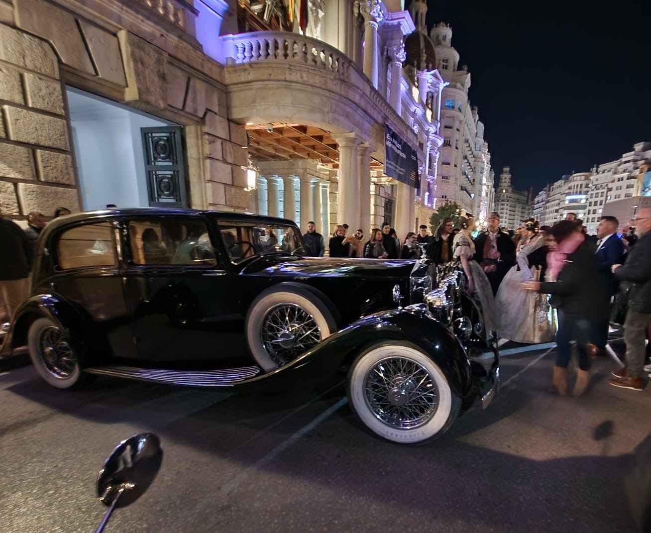 Las falleras en la plaza del Ayuntamiento de Valencia antes de dirigirse al Palacio de Congresos en vehículos históricos