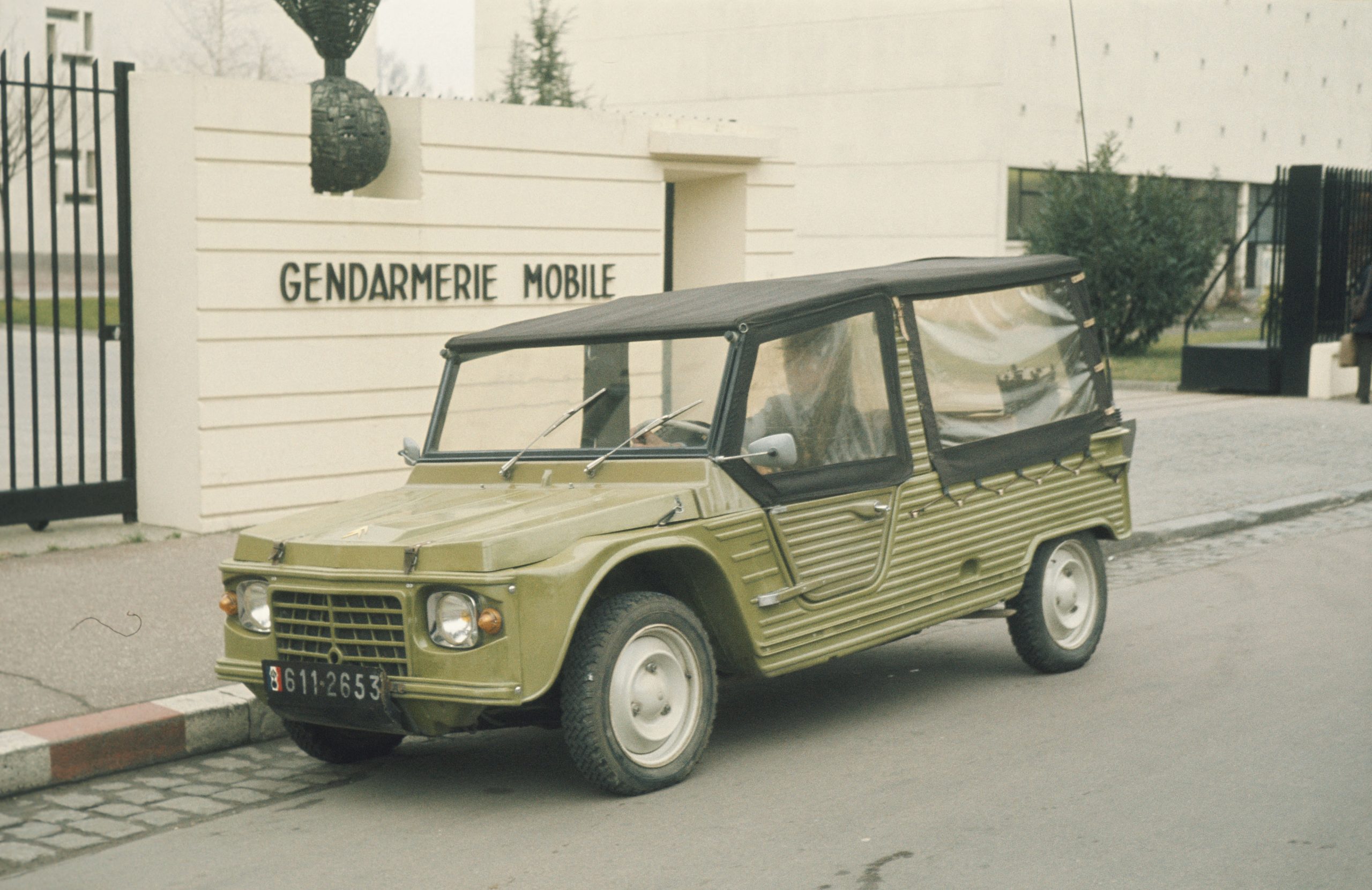 UN CITROËN MEHARI DE LA GENDARMERÍA NACIONAL MÓVIL EN  ESTACIONADO DELANTE DE UN LOCAL DE LA GENDARMERÍA  MÓVIL EN 1974